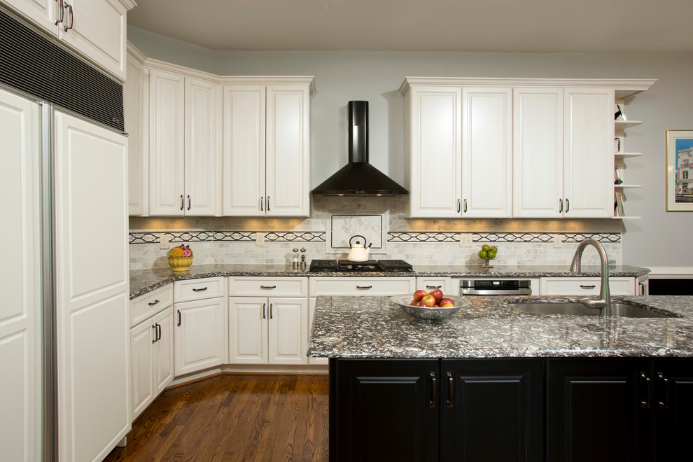 Inspiration for a traditional u-shaped eat-in kitchen in DC Metro with a single-bowl sink, white cabinets, quartz benchtops, grey splashback, glass tile splashback, black appliances, medium hardwood floors and with island.