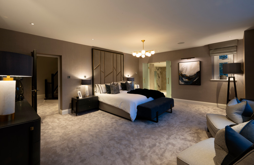 Modelo de dormitorio principal de estilo americano grande con paredes marrones, moqueta, suelo beige y papel pintado