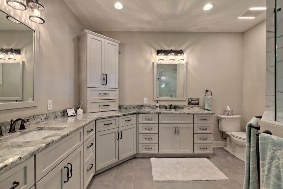 This is an example of a large arts and crafts master bathroom in Atlanta with shaker cabinets, grey cabinets, an open shower, granite benchtops, grey benchtops, a double vanity, a built-in vanity, a two-piece toilet, grey walls, porcelain floors, an undermount sink, grey floor, an open shower and a niche.