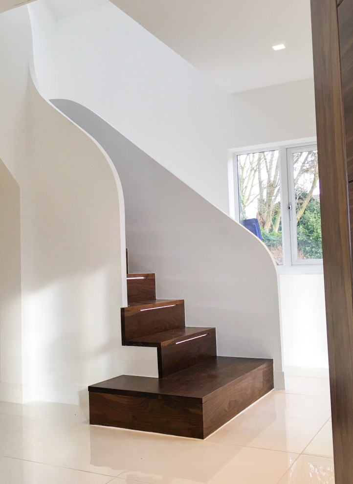 Réalisation d'un escalier design en L de taille moyenne avec des marches en bois, des contremarches en bois et éclairage.