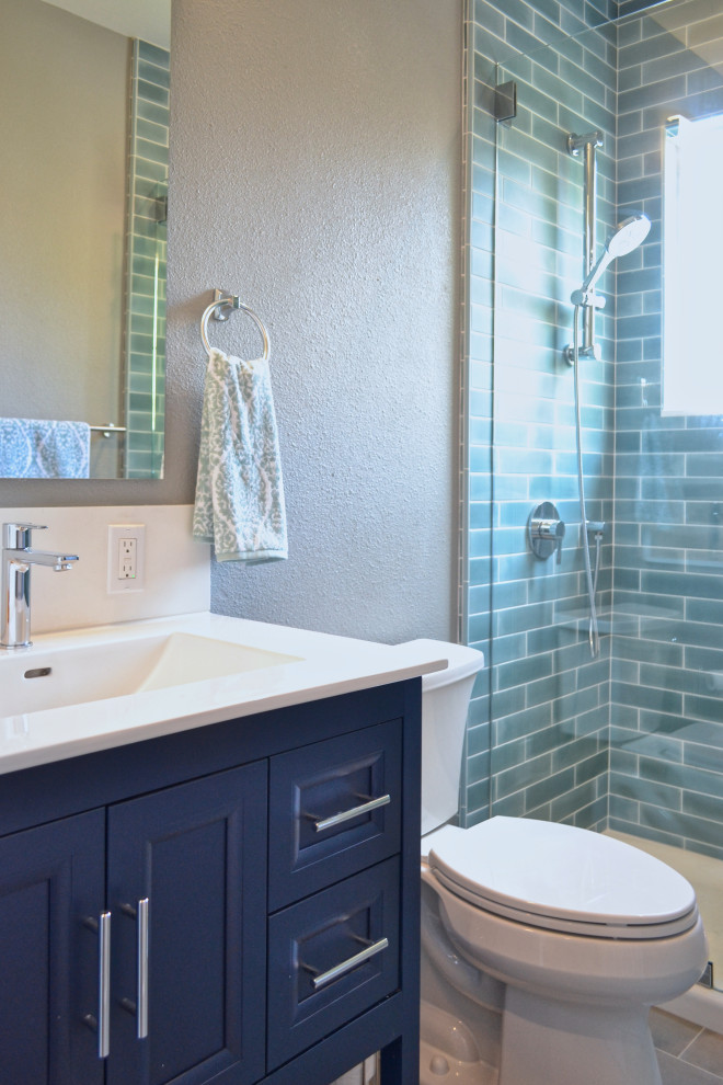 Пример оригинального дизайна: ванная комната среднего размера в стиле неоклассика (современная классика) с фасадами с утопленной филенкой, синими фасадами, душем в нише, зеленой плиткой, керамической плиткой, полом из керамической плитки, душевой кабиной, монолитной раковиной, столешницей из искусственного кварца, серым полом, душем с распашными дверями, белой столешницей, тумбой под одну раковину и напольной тумбой