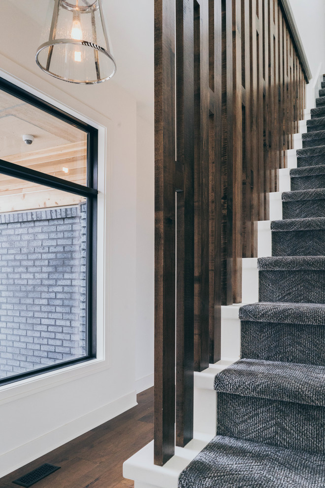 Inspiration for a transitional carpeted l-shaped wood railing staircase remodel in Omaha with carpeted risers