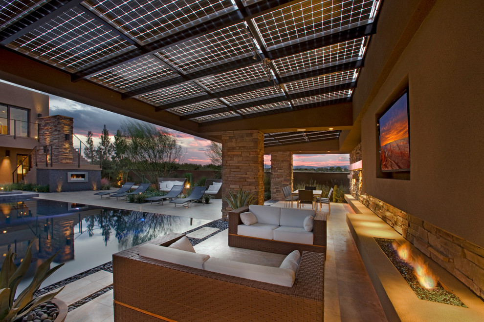Expansive contemporary backyard patio in Las Vegas with a fire feature and an awning.