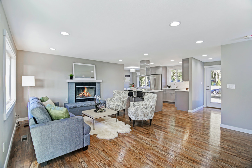 Mid-sized transitional l-shaped medium tone wood floor and brown floor eat-in kitchen photo in Seattle with an undermount sink, shaker cabinets, gray cabinets, quartz countertops, white backsplash, ceramic backsplash, stainless steel appliances, an island and white countertops