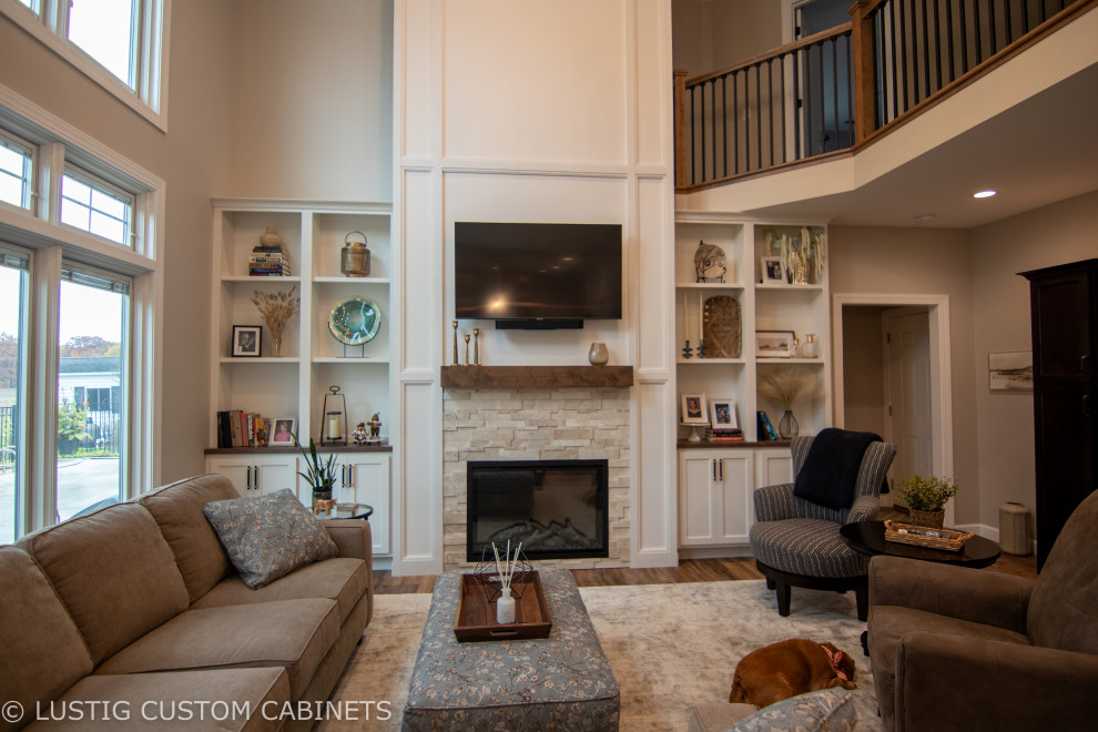 Example of a large transitional l-shaped laminate floor and brown floor open concept kitchen design with an undermount sink, flat-panel cabinets, white cabinets, quartz countertops, white backsplash, ceramic backsplash, stainless steel appliances, an island and white countertops