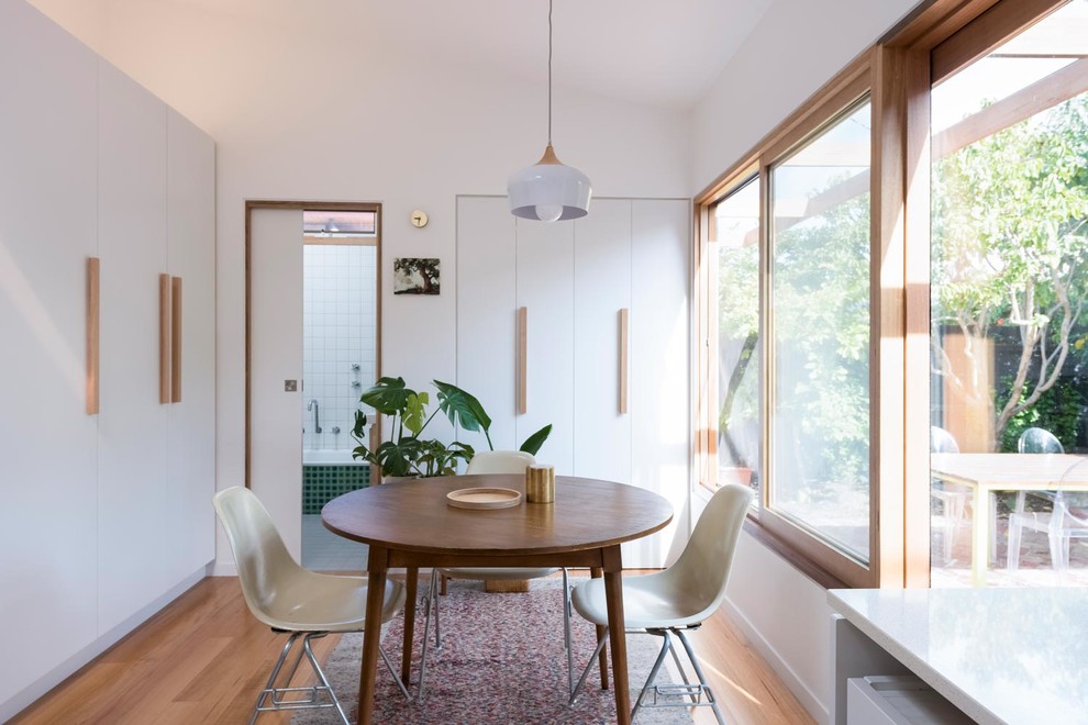 Design ideas for a small scandinavian kitchen/dining combo in Melbourne with white walls, light hardwood floors and brown floor.