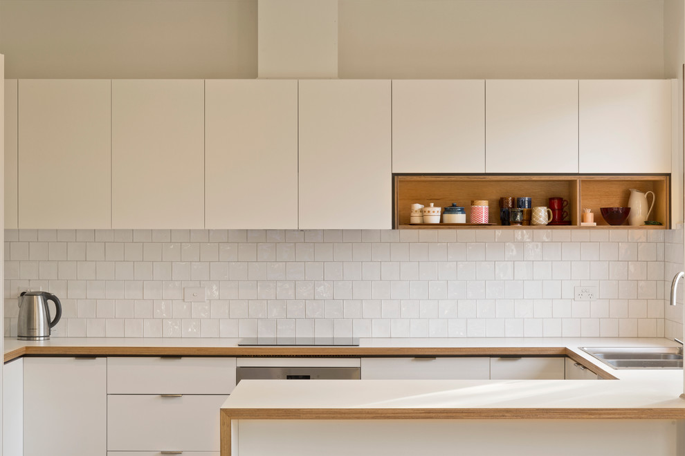 Inspiration for a mid-sized contemporary u-shaped kitchen in Melbourne with laminate benchtops, white splashback and ceramic splashback.