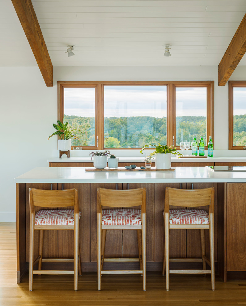 Kitchen - coastal medium tone wood floor kitchen idea in Boston with flat-panel cabinets, medium tone wood cabinets, window backsplash, an island and white countertops
