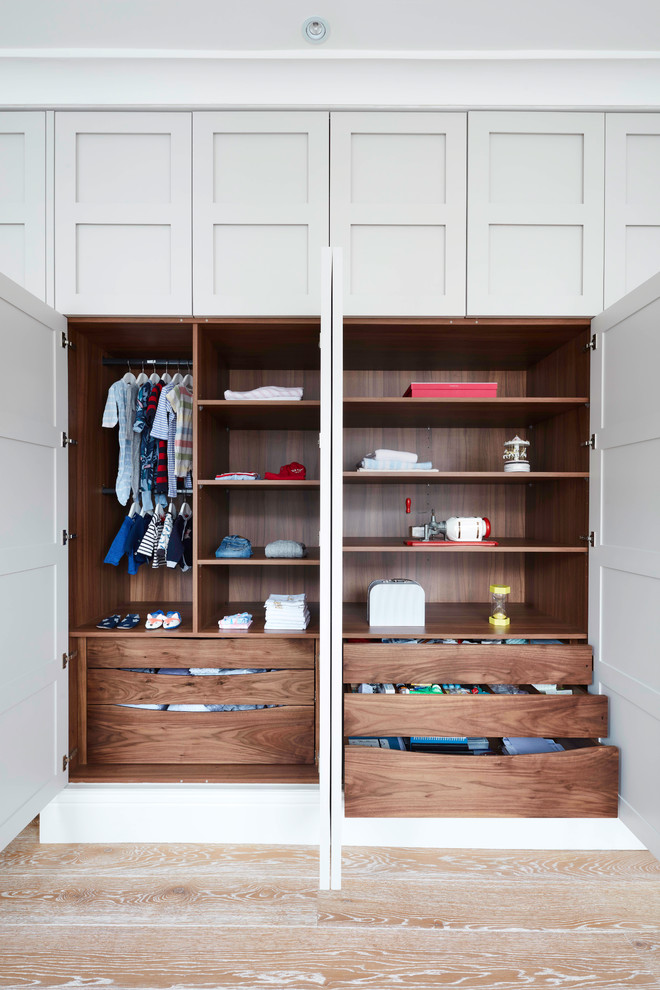 Inspiration for a large traditional gender-neutral built-in wardrobe in London with medium hardwood floors, recessed-panel cabinets, grey cabinets and beige floor.