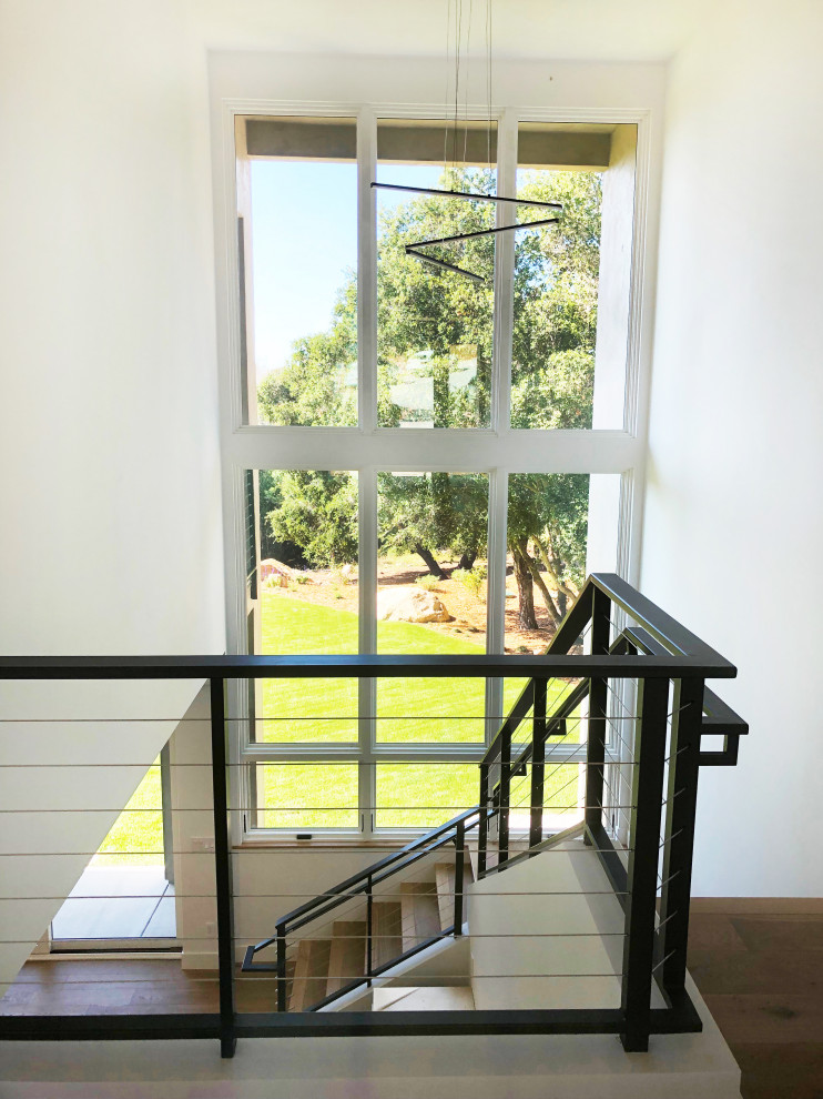 Contemporary wood l-shaped staircase in Santa Barbara with wood risers and metal railing.