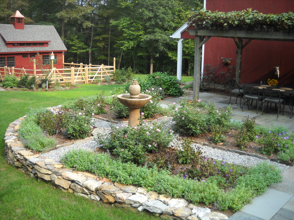 Photo of a country backyard garden for summer in New York with a garden path and natural stone pavers.
