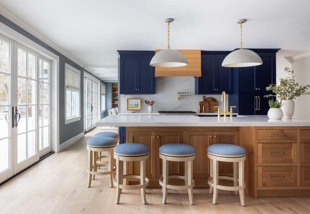 Inspiration for a large transitional l-shaped light wood floor enclosed kitchen remodel in New York with an undermount sink, quartz countertops, white backsplash, stone slab backsplash, an island and white countertops