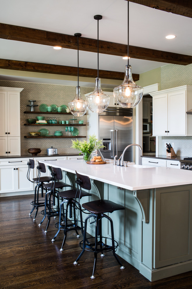 Design ideas for a traditional l-shaped kitchen in Nashville with a farmhouse sink, shaker cabinets, white cabinets, mosaic tile splashback, stainless steel appliances, dark hardwood floors and with island.