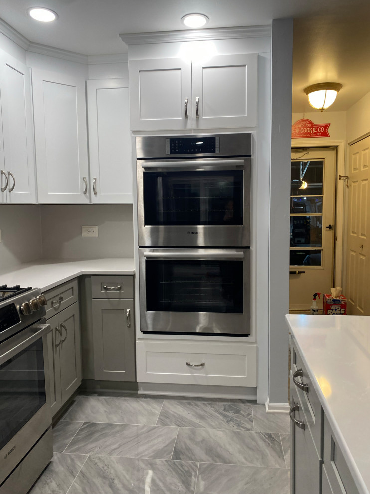 Example of a mid-sized transitional l-shaped eat-in kitchen design in Chicago with shaker cabinets, quartz countertops and an island
