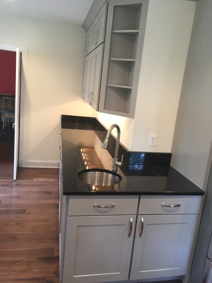 Example of a large transitional l-shaped dark wood floor eat-in kitchen design in Baltimore with an undermount sink, shaker cabinets, white cabinets, marble countertops, gray backsplash, stone slab backsplash, stainless steel appliances and an island