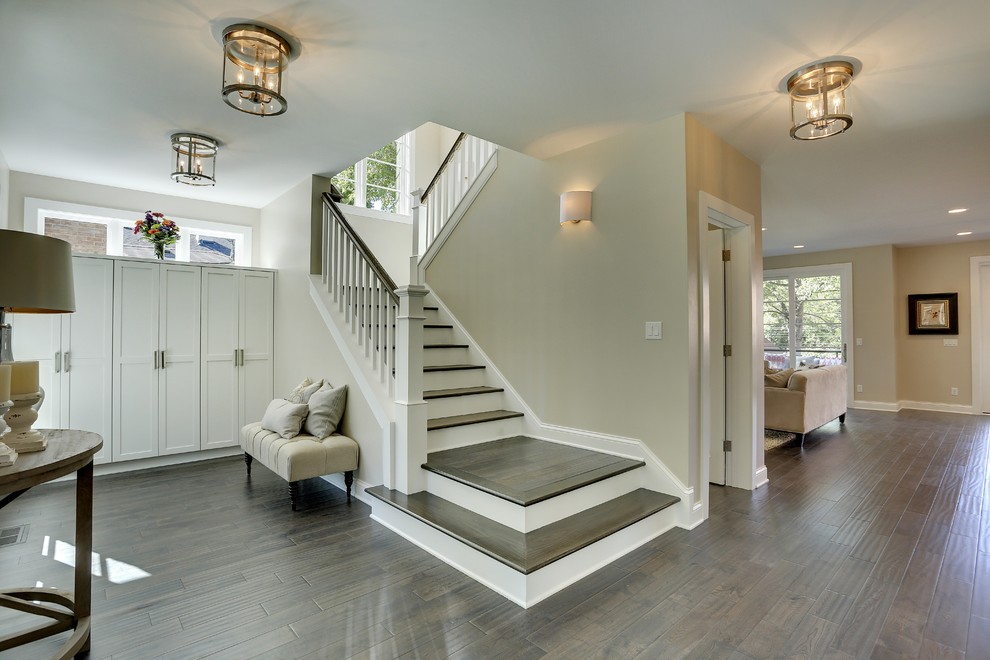 Photo of a large transitional foyer in Minneapolis with grey walls, dark hardwood floors, a single front door, a glass front door and brown floor.