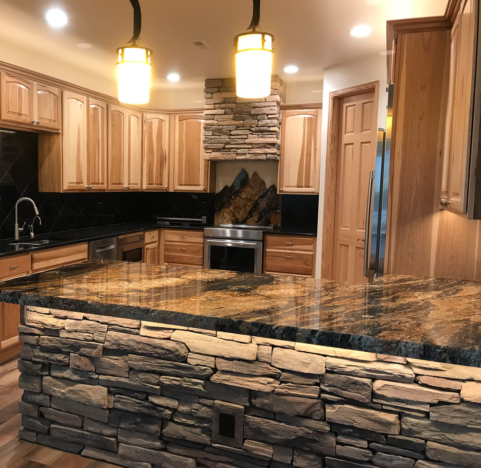 Large traditional l-shaped open plan kitchen in Denver with an undermount sink, recessed-panel cabinets, medium wood cabinets, black splashback, stone slab splashback, stainless steel appliances, medium hardwood floors, a peninsula, brown floor, granite benchtops and multi-coloured benchtop.
