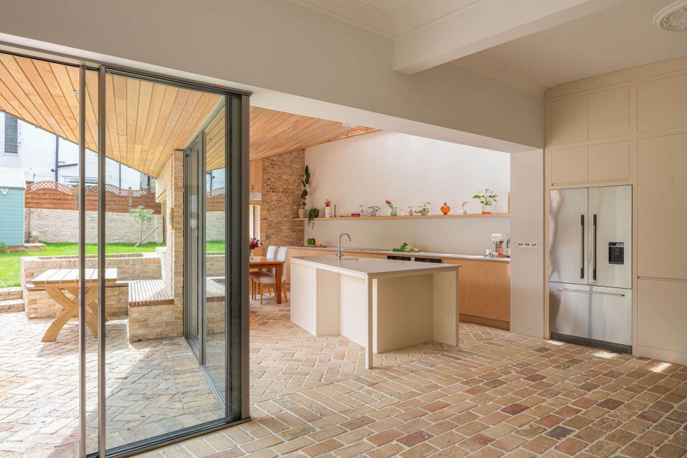 Esempio di una grande cucina nordica con ante lisce, ante in legno chiaro, top in superficie solida, pavimento in mattoni e top grigio