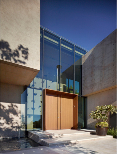 This is an example of a large modern front door in Los Angeles with grey walls, marble floors, a double front door, a medium wood front door and beige floor.