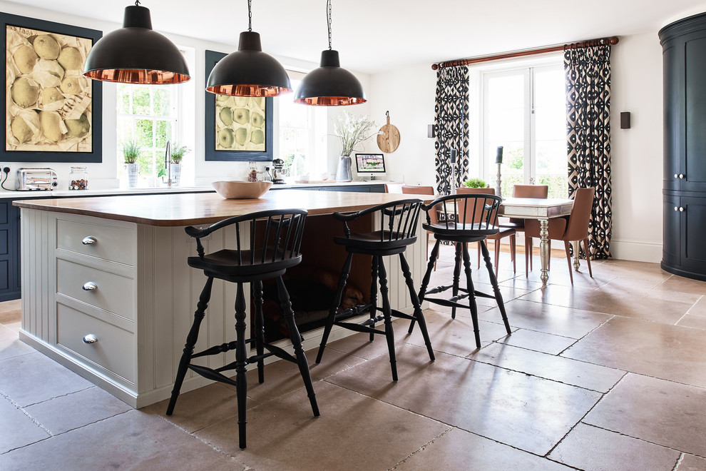 This is an example of an eclectic kitchen in Wiltshire with limestone floors.