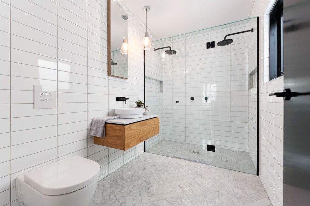 This is an example of a contemporary 3/4 bathroom in Melbourne with a double shower, a wall-mount toilet, white tile, subway tile, white walls, a vessel sink, flat-panel cabinets, medium wood cabinets and a hinged shower door.