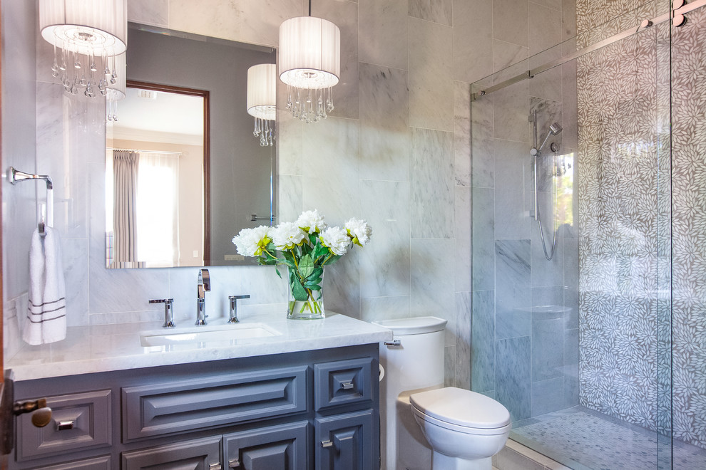Mid-sized transitional 3/4 bathroom in San Diego with raised-panel cabinets, grey cabinets, an alcove shower, a two-piece toilet, gray tile, white tile, marble, grey walls, an undermount sink, marble benchtops and a sliding shower screen.