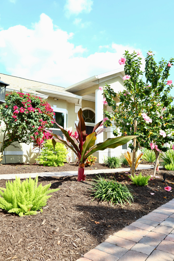Inspiration for a mid-sized tropical partial sun front yard mulch landscaping in Other for summer.