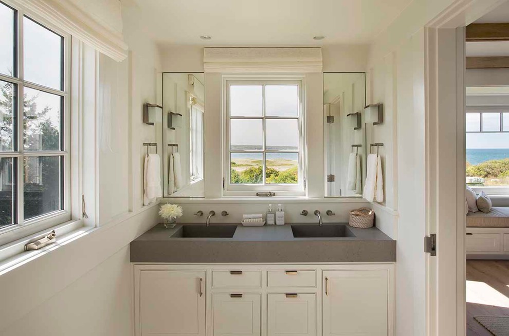 Beach style master bathroom in Boston with an integrated sink, beaded inset cabinets, white cabinets, concrete benchtops and white walls.