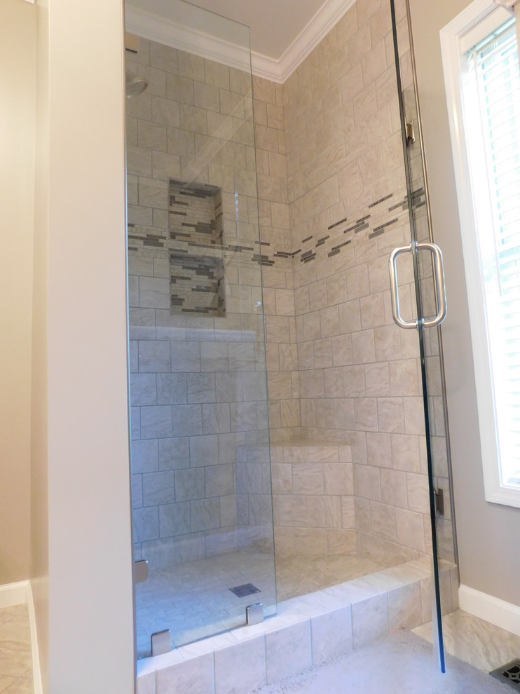 Large transitional master gray tile and ceramic tile ceramic tile corner bathtub photo with raised-panel cabinets, medium tone wood cabinets, a two-piece toilet, beige walls, an undermount sink and granite countertops