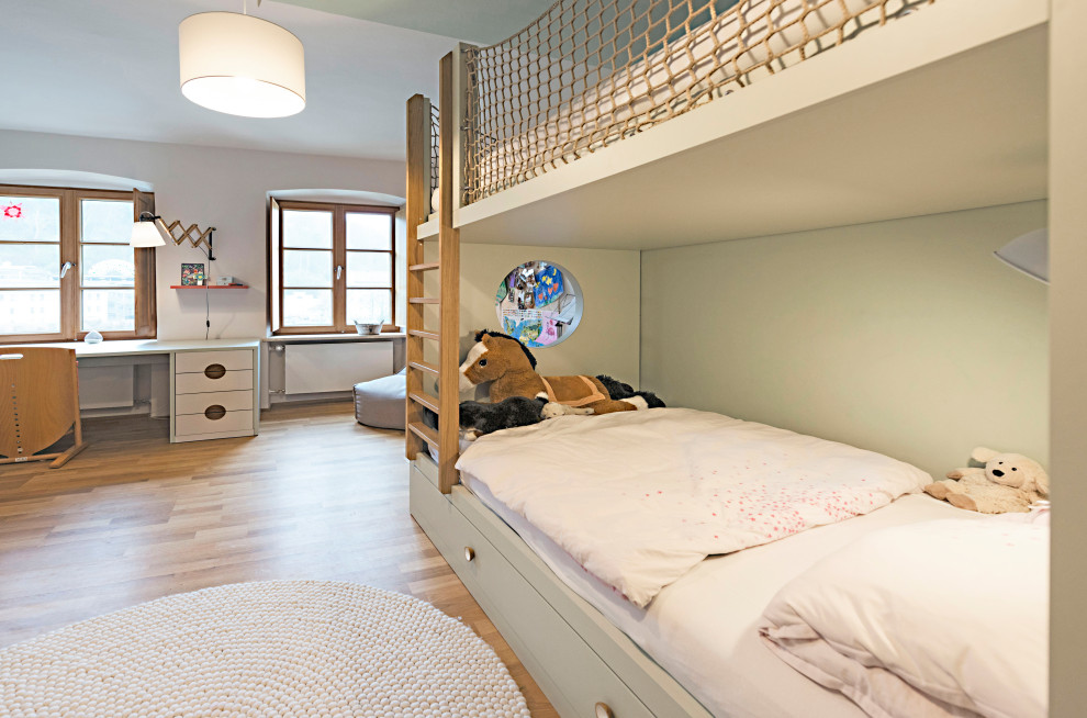 Diseño de habitación de niña de 4 a 10 años actual grande con paredes verdes, suelo de madera en tonos medios y suelo marrón