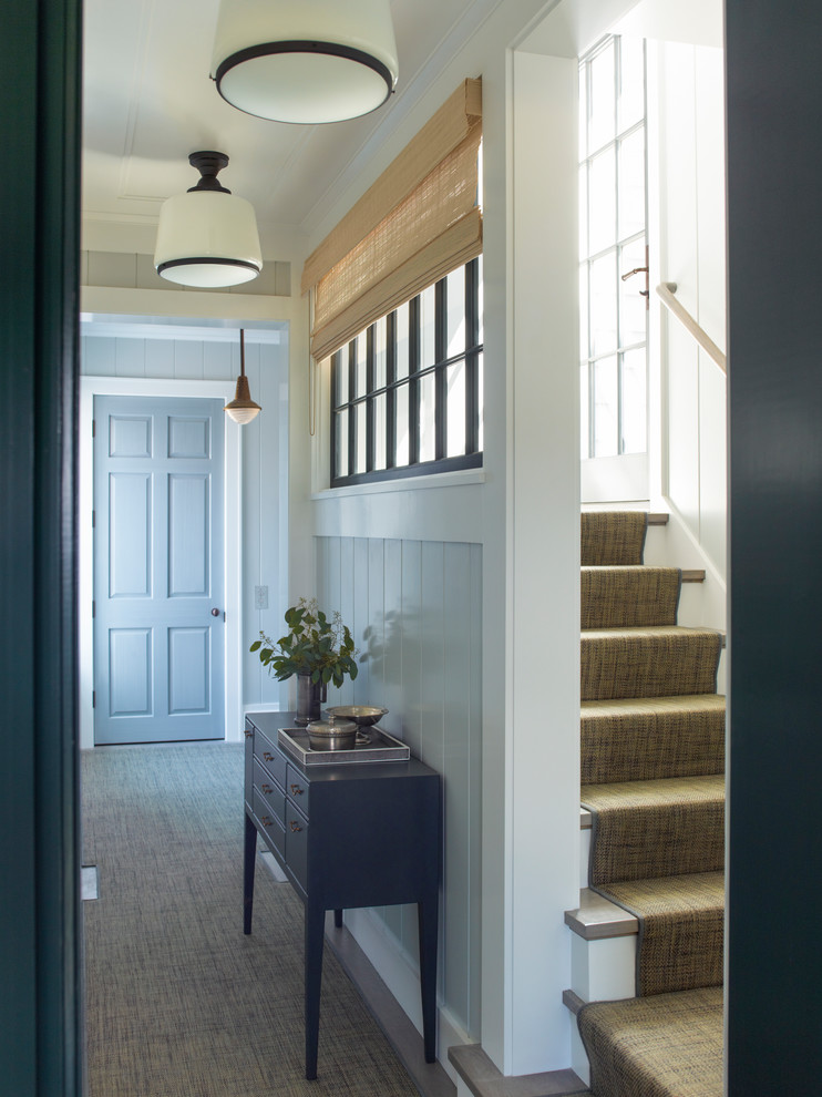 This is an example of a mid-sized country foyer in New York with grey walls, carpet, a single front door, a blue front door and brown floor.