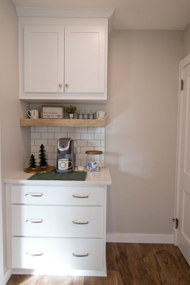 Inspiration for a mid-sized rustic galley vinyl floor and brown floor enclosed kitchen remodel with recessed-panel cabinets, white cabinets, quartz countertops, white backsplash, subway tile backsplash, stainless steel appliances, a peninsula and white countertops
