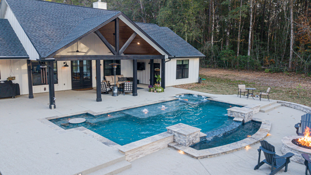 Cette image montre une grande piscine arrière rustique rectangle avec une terrasse en bois.