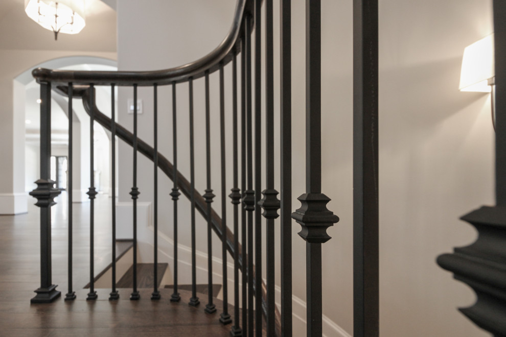 Photo of a large classic wood floating metal railing staircase in DC Metro with painted wood risers.
