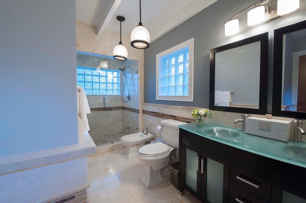 Idee per una stanza da bagno padronale stile marinaro di medie dimensioni con lavabo integrato, ante lisce, ante nere, top in vetro, doccia alcova, WC a due pezzi, piastrelle beige, piastrelle in pietra, pareti grigie e pavimento in marmo