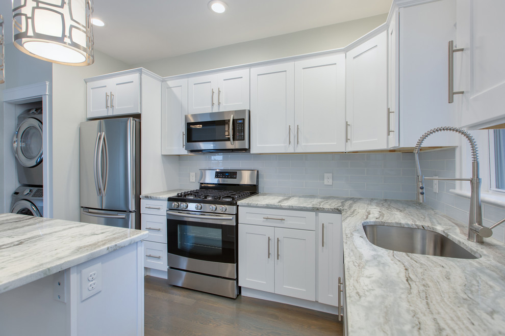 Enclosed kitchen - mid-sized transitional l-shaped dark wood floor and brown floor enclosed kitchen idea in Boston with an undermount sink, shaker cabinets, white cabinets, marble countertops, gray backsplash, subway tile backsplash, stainless steel appliances, an island and white countertops