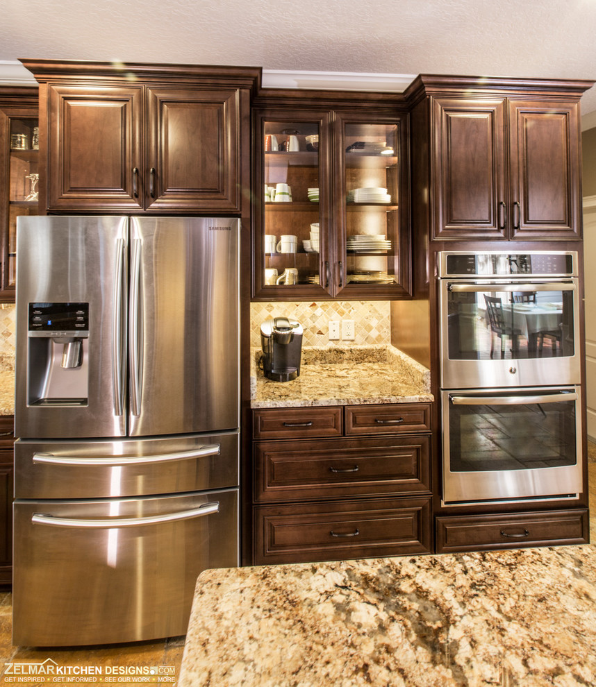 This is an example of a mid-sized traditional u-shaped kitchen pantry in Orlando with an undermount sink, raised-panel cabinets, dark wood cabinets, granite benchtops, multi-coloured splashback, stone tile splashback and with island.