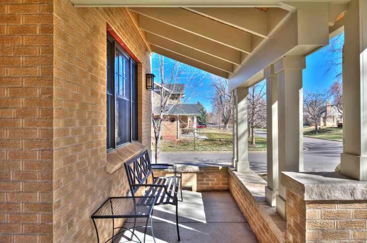 Large traditional front yard verandah in Denver with a roof extension.
