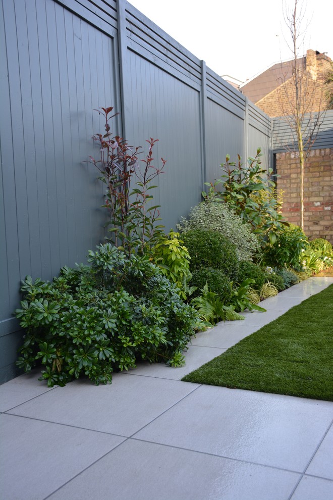 Mid-sized contemporary backyard partial sun garden in London.