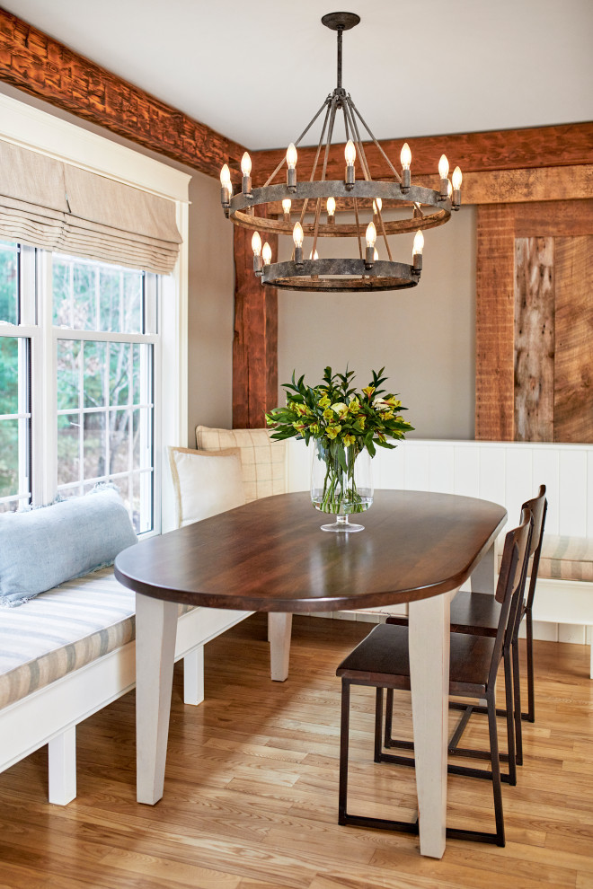 Réalisation d'une salle à manger champêtre en bois avec une banquette d'angle, un mur beige, parquet clair et poutres apparentes.