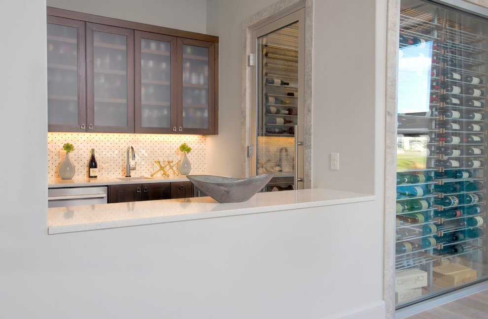 Inspiration for a mid-sized contemporary u-shaped wet bar in Austin with an undermount sink, glass-front cabinets, medium wood cabinets, onyx benchtops, white splashback, mosaic tile splashback and porcelain floors.