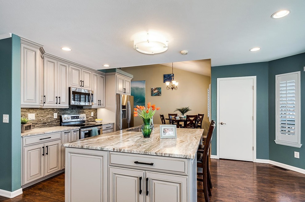 Example of a transitional galley eat-in kitchen design in Denver with a double-bowl sink, raised-panel cabinets, gray cabinets, granite countertops, gray backsplash and an island