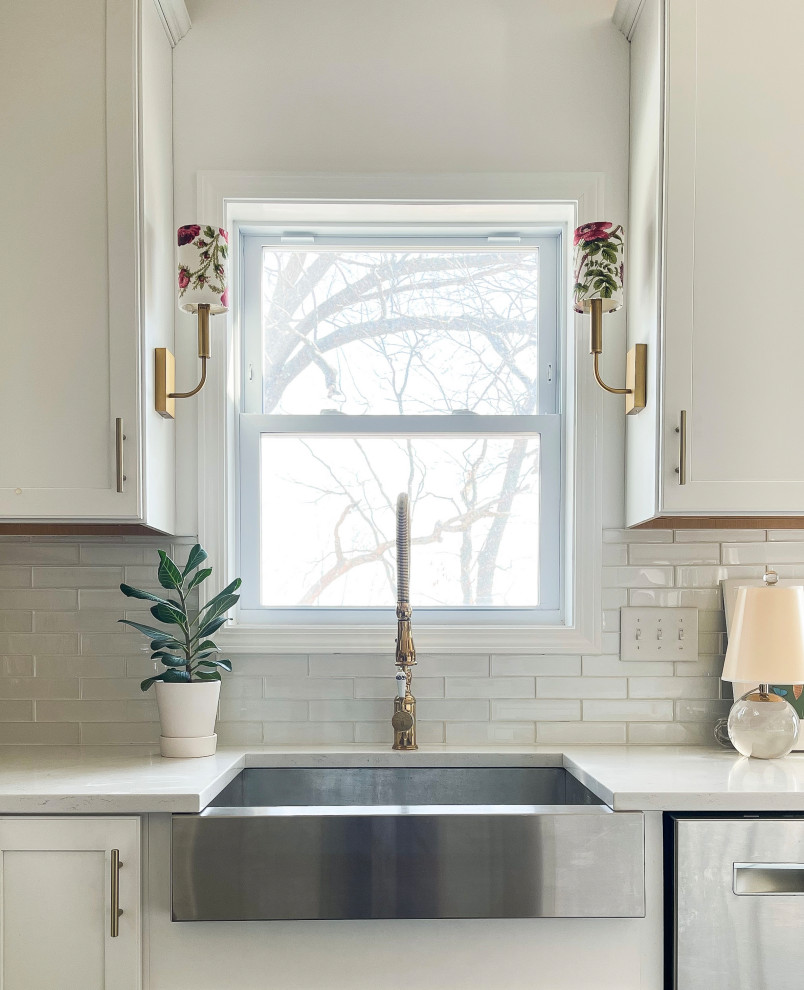 Eat-in kitchen - mid-sized transitional u-shaped dark wood floor eat-in kitchen idea in Boston with a farmhouse sink, shaker cabinets, white cabinets, glass tile backsplash, stainless steel appliances, an island and white countertops