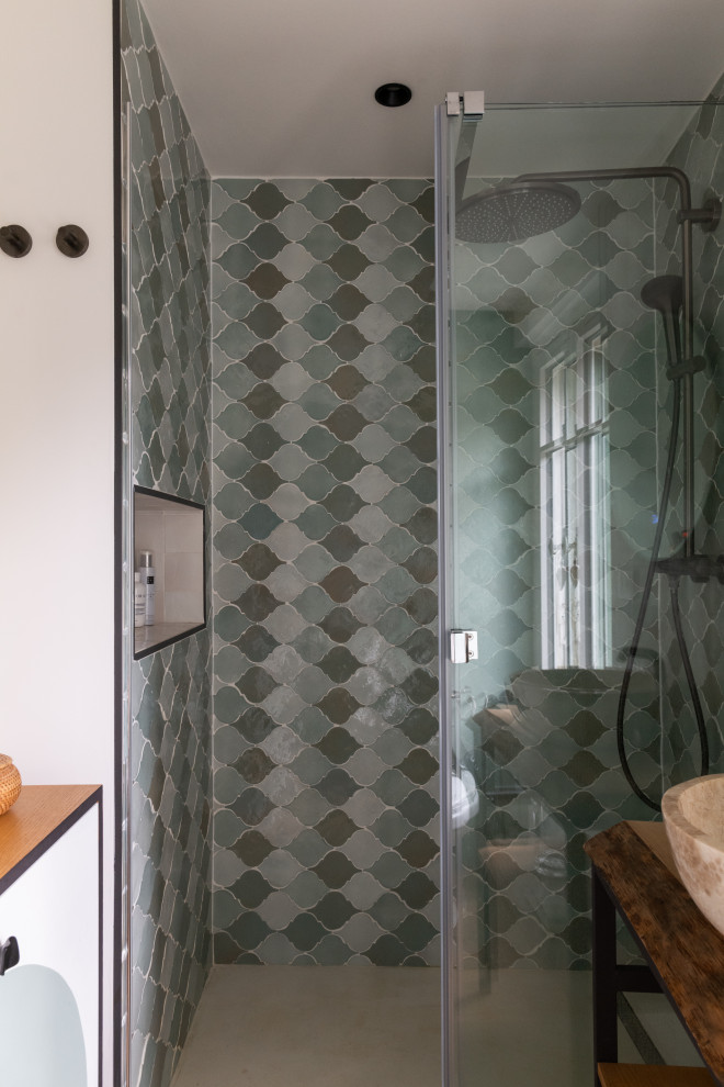 Foto di una piccola stanza da bagno con doccia mediterranea con WC monopezzo, piastrelle verdi, pareti verdi, parquet chiaro, lavabo da incasso, top in legno, porta doccia scorrevole, nicchia e un lavabo