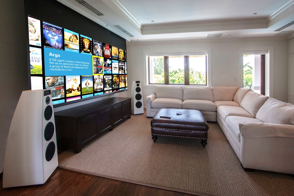 Photo of a large modern home theatre in Sussex with white walls, dark hardwood floors and a projector screen.