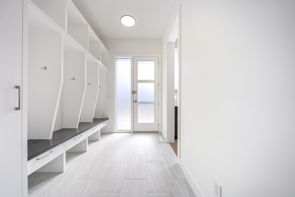 Inspiration for a mid-sized transitional ceramic tile and gray floor mudroom remodel in Calgary with white walls and a glass front door