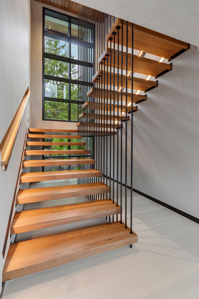 Пример оригинального дизайна: лестница в современном стиле с деревянными ступенями и деревянными перилами без подступенок