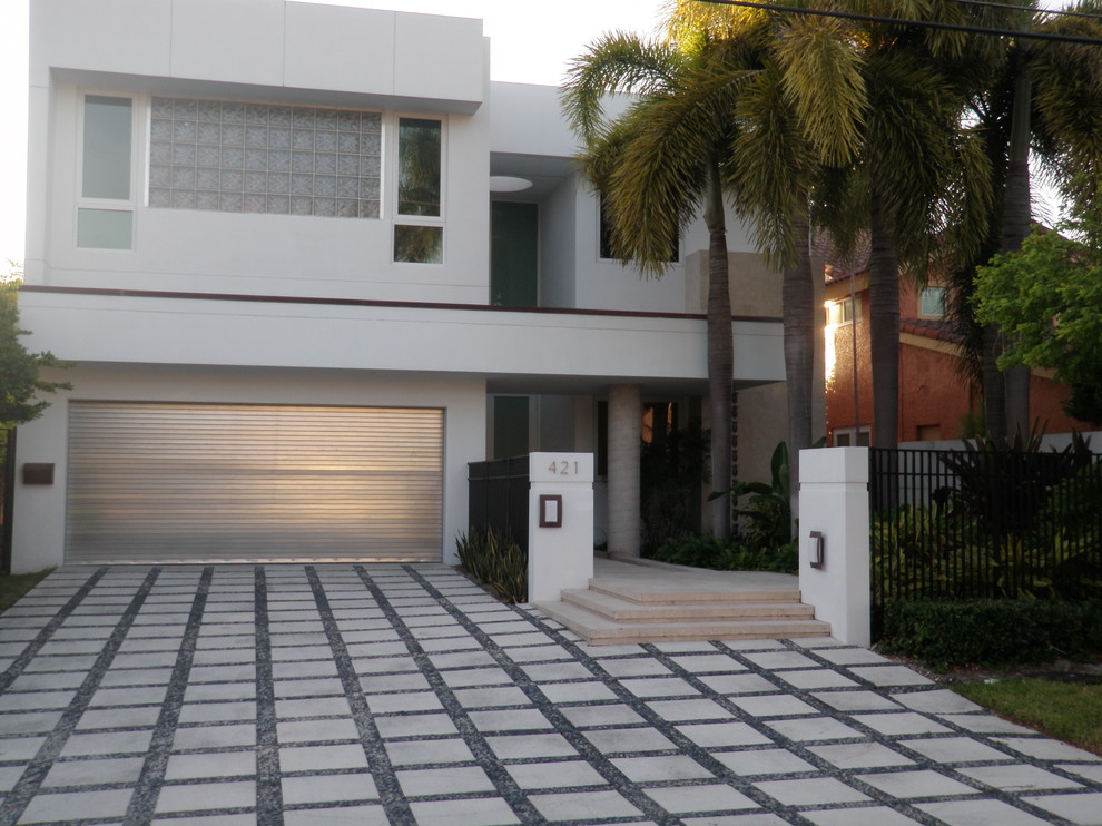 Design ideas for a large modern two-storey concrete white exterior in Miami with a flat roof.