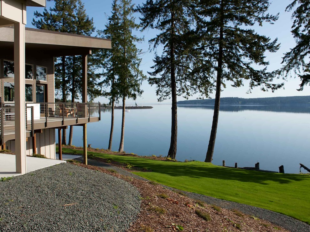 This is an example of a beach style sloped full sun garden for fall in Seattle with gravel.