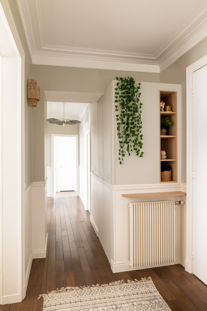 Foto di un grande ingresso o corridoio minimal con pareti beige, pavimento in legno massello medio, pavimento marrone e boiserie